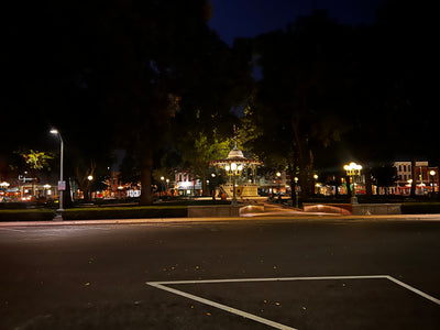 Downtown Oskaloosa street at night, lit storefronts along the square