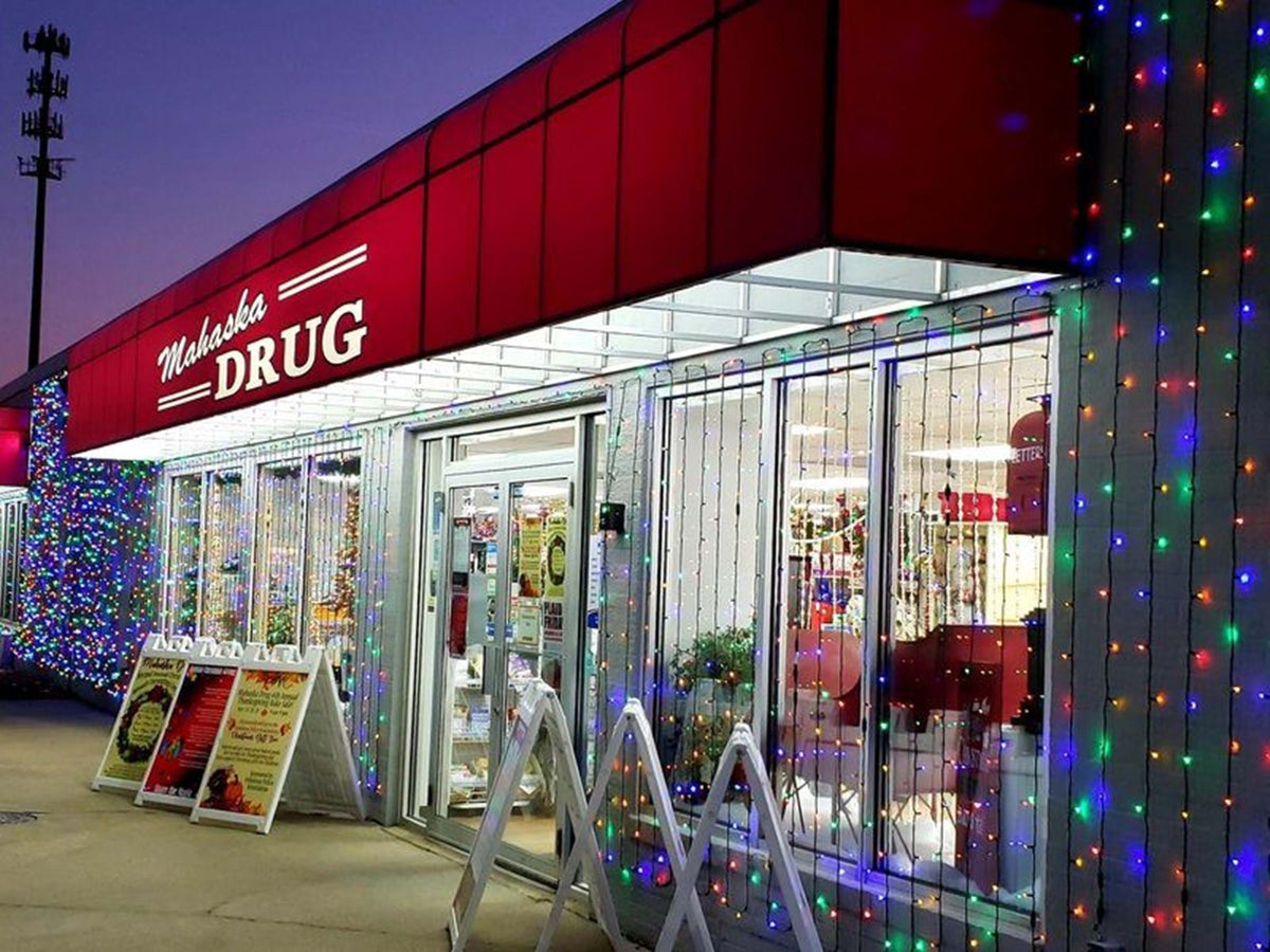 Mahaska Drug storefront lit with Christmas lights at night