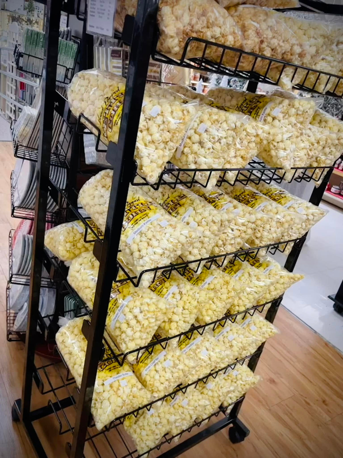 Bags of caramel and cheddar kettle corn stacked on the in-store display rack