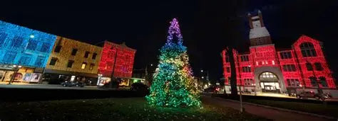 Buildings around Oskaloosa's square lit in color beside the city Christmas tree