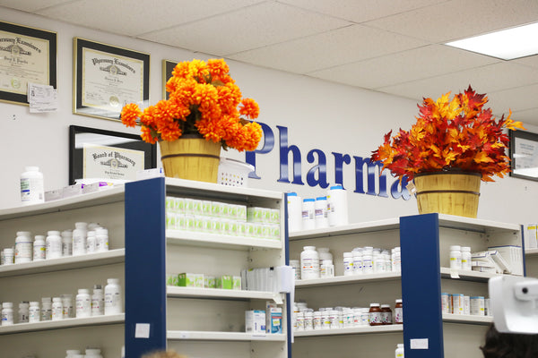Pharmacy counter at Mahaska Drug with fall flower arrangements on the end caps